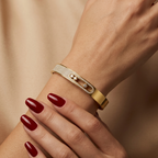 Gold-tone stainless steel bracelet featuring moving, stone-studded elements.