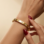 Stainless steel bracelet with gold-tone segments and zircon.