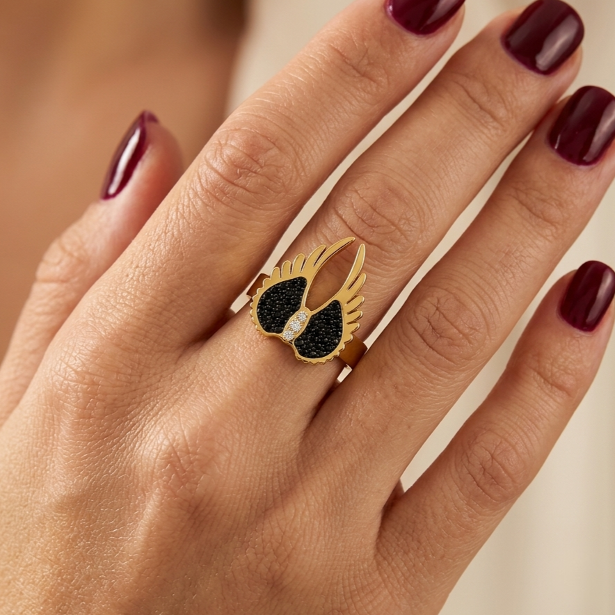 Open stainless steel ring with angel wings and black zirconia.
