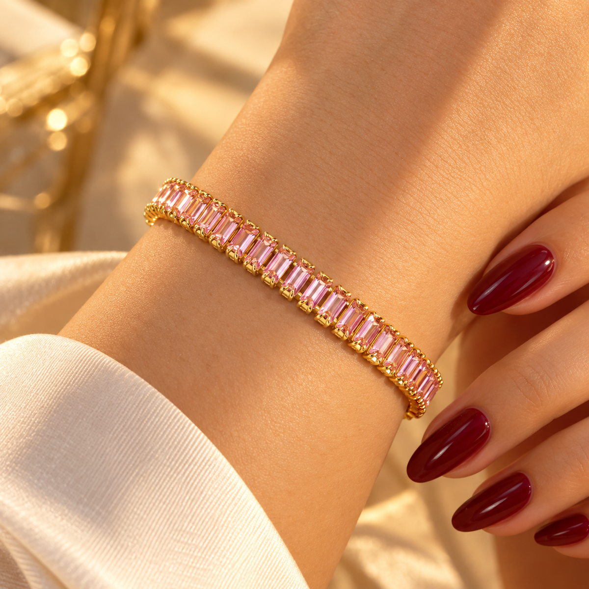 Gold-tone stainless steel tennis bracelet set with pink zircon stones.