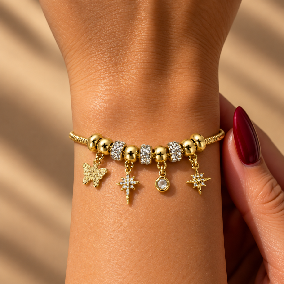 Stainless steel bracelet with snake-style beads and star and butterfly charms.
