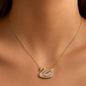 Gold-plated stainless steel necklace featuring a swan design adorned with a charming pink stone.