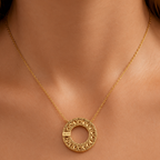 Gold-plated stainless steel necklace with a circular pendant featuring geometric patterns.