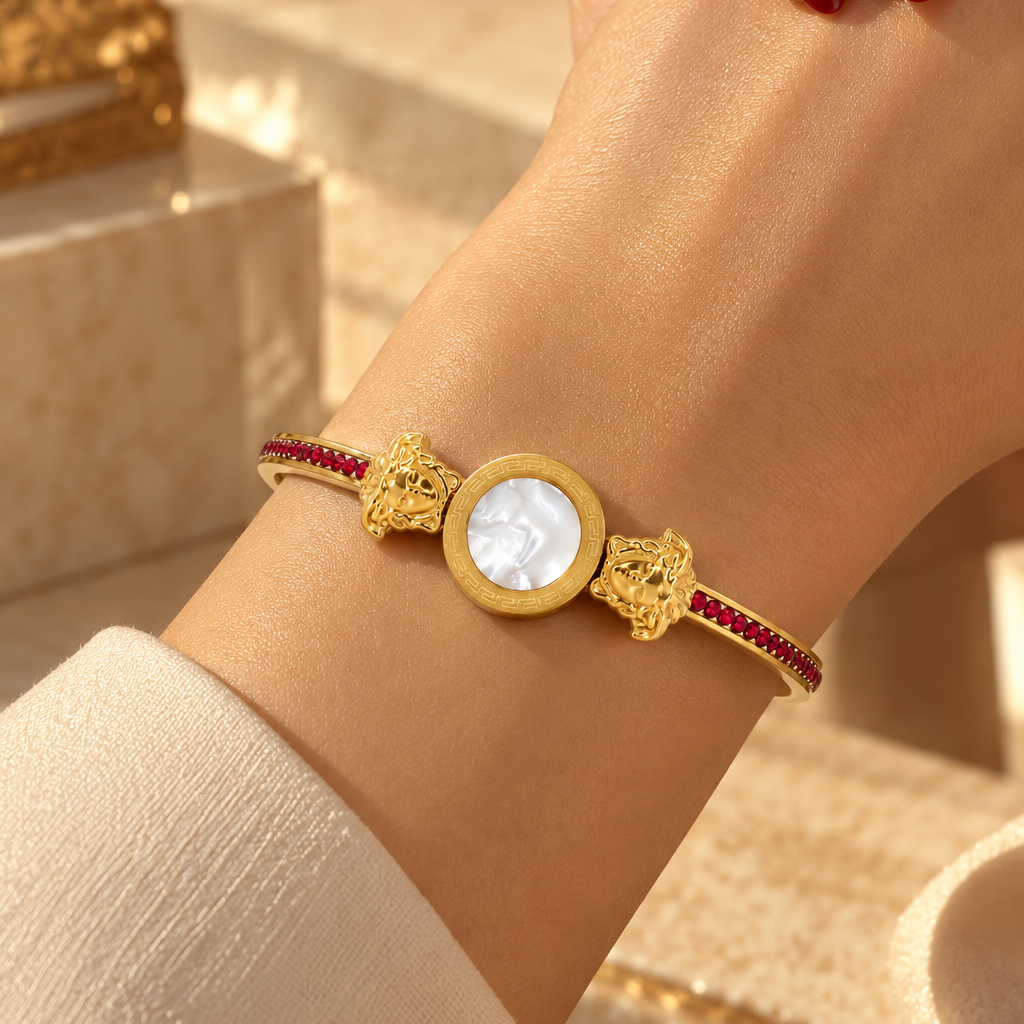 Stainless steel bracelet featuring a mother-of-pearl disc and a Medusa motif with red zircon.