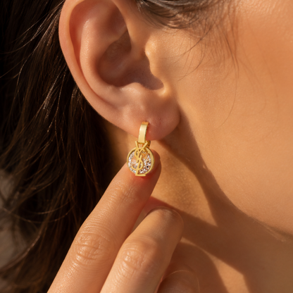 Gold-plated stainless steel earrings with an interlocking letter design and crystal stone