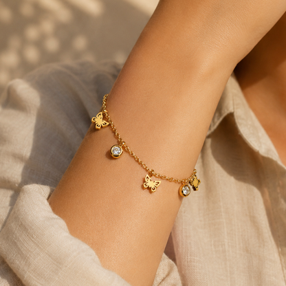 Gold-plated stainless steel bracelet with a butterfly design and dangling crystals