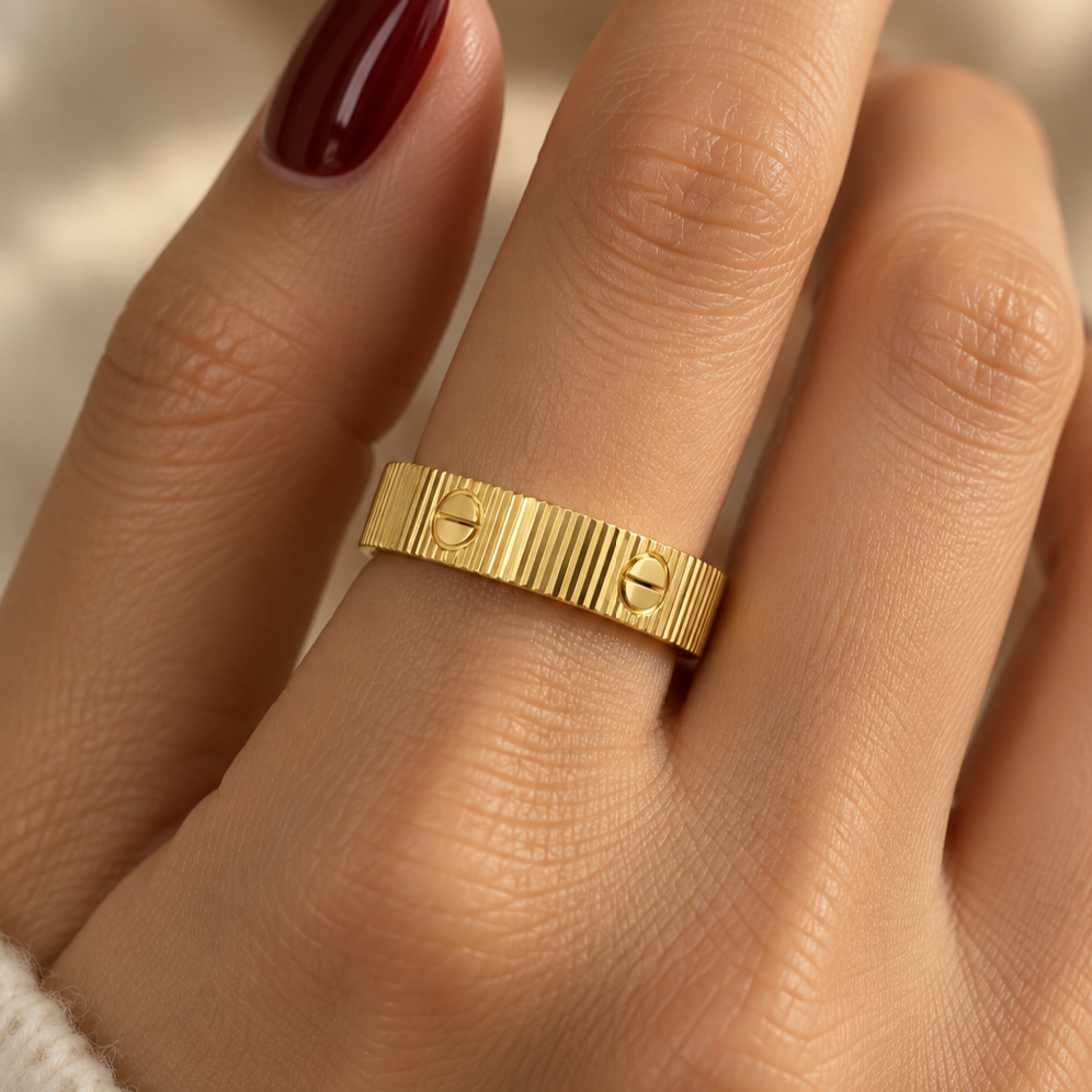 Faceted stainless steel ring with gold screw-head detailing.