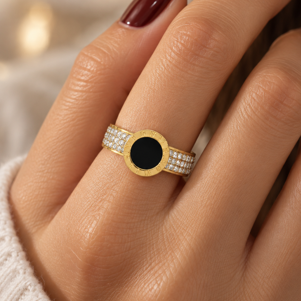 Open stainless steel ring with a black disc and Roman numerals.