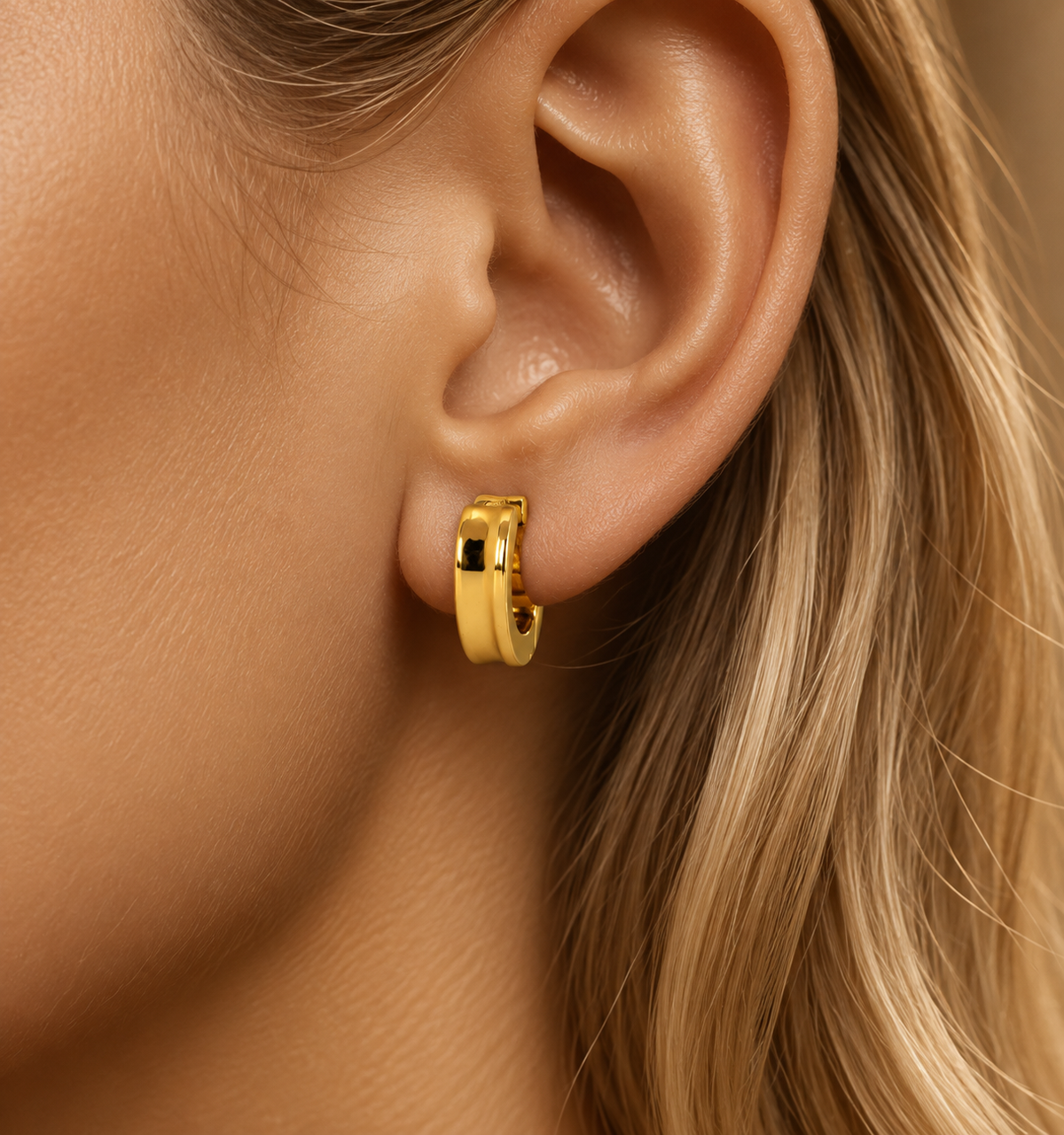 Smooth stainless steel hoop earrings with a concave gold surface.