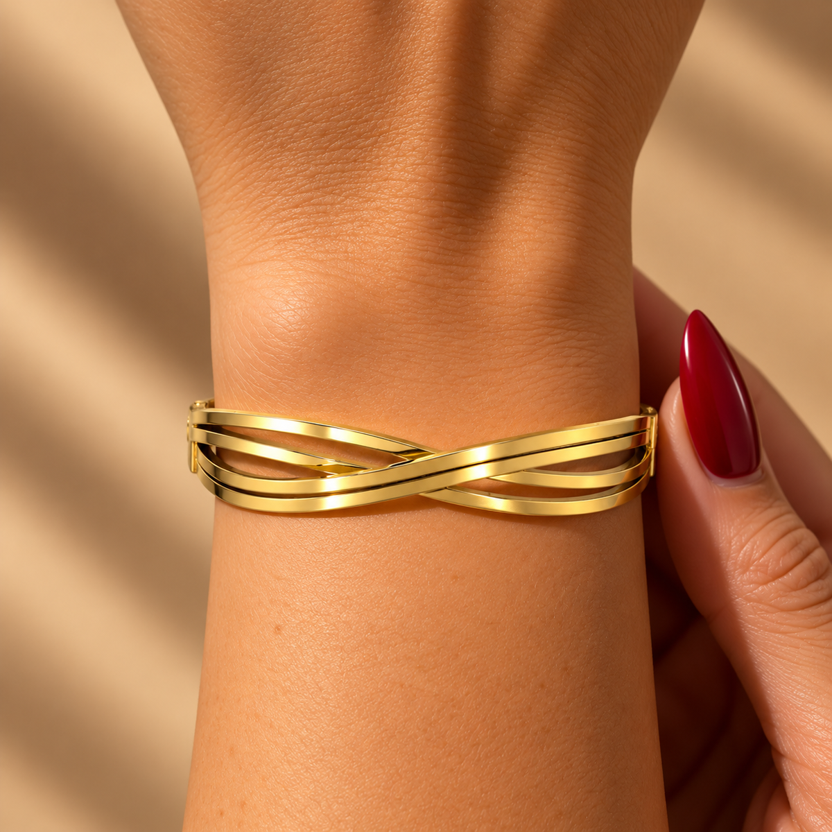 Stainless steel bracelet with interlocking gold-tone lines.