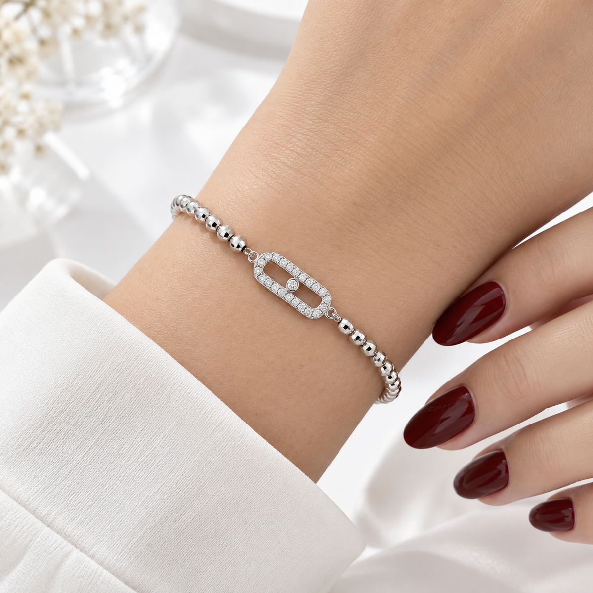 Stainless steel bracelet featuring silver beads and a rectangular, stone-set link.