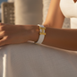 A modern bracelet with a white strap and a gold "H" logo – a touch of classic elegance