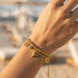 Stainless steel bracelet with gold plating and trendy charms (V letter and blue stones) - elegant design